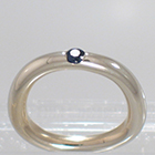 14 Karat White Gold barstock band with flush-set round blue sapphire