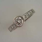 platinum round bezel diamond with channel-set side stones