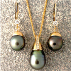 black pearl and diamond ensemble in 14 karat yellow gold.