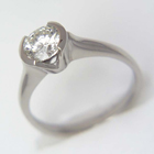 Platinum ring with 1.02 carat round brilliant diamond in semi-bezel on thin rounded shank with inward-sweeping shoulders.